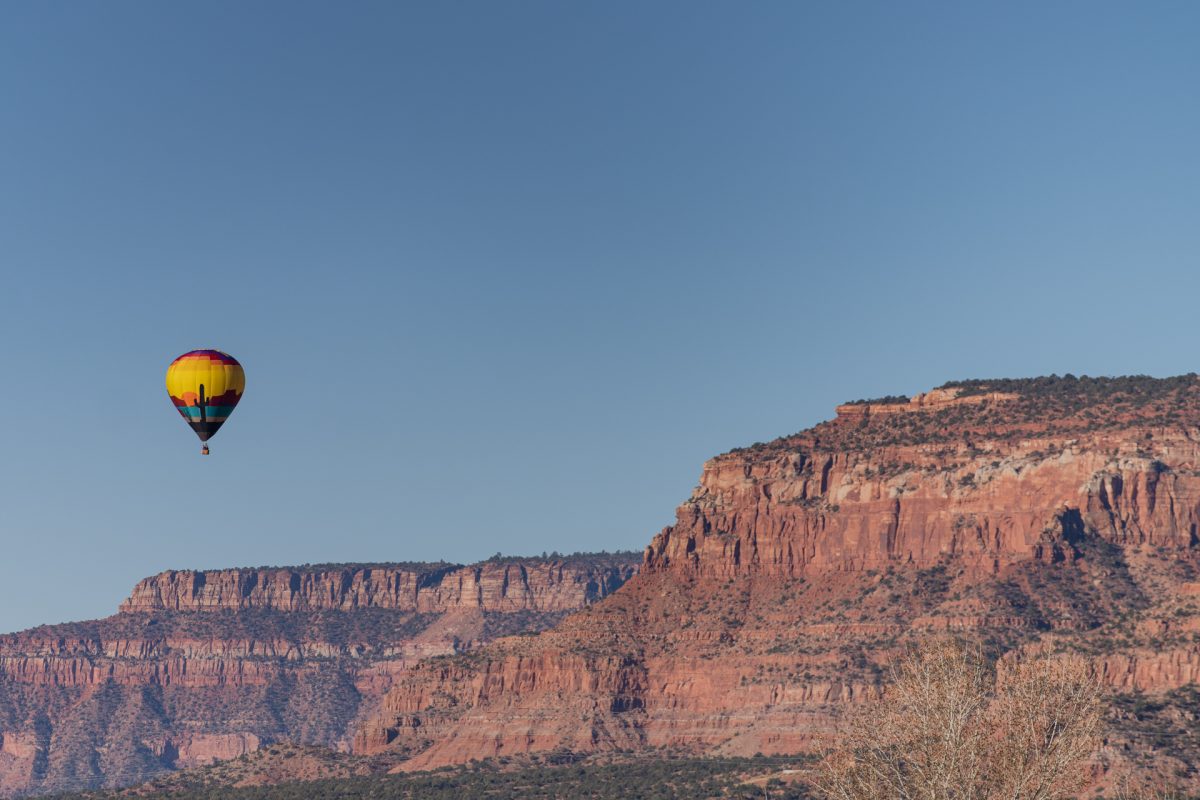 A hot air balloon floats above the red rocks of Kanab, Utah during the Balloons and Tunes Roundup.