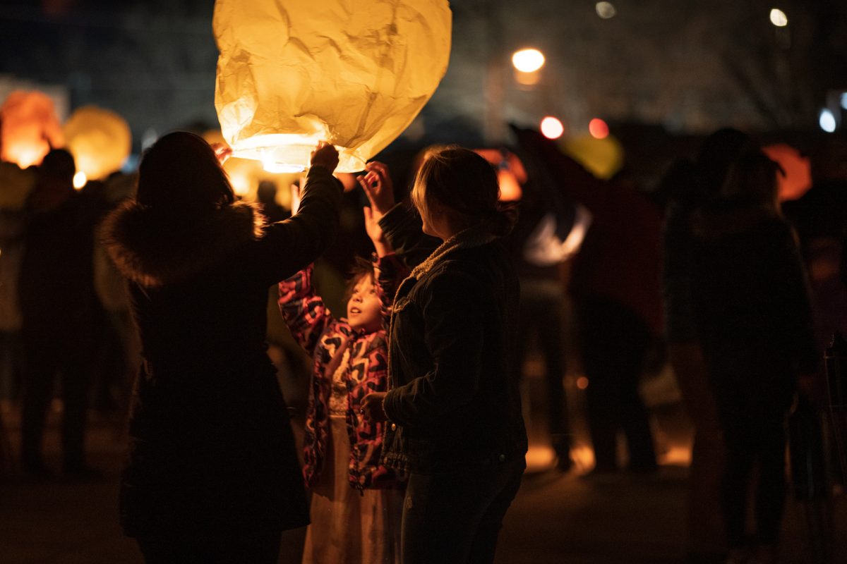 A family lights a lantern during the Lantern Festival portion of the Balloons and Tunes Roundup in Kanab, Utah.