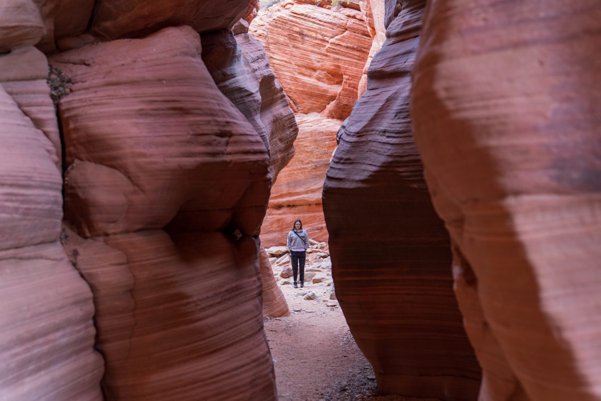 A woman stands at the end of Peek-A-Boo Slot canyon, a unique destination to visit in or near Kanab, Utah.