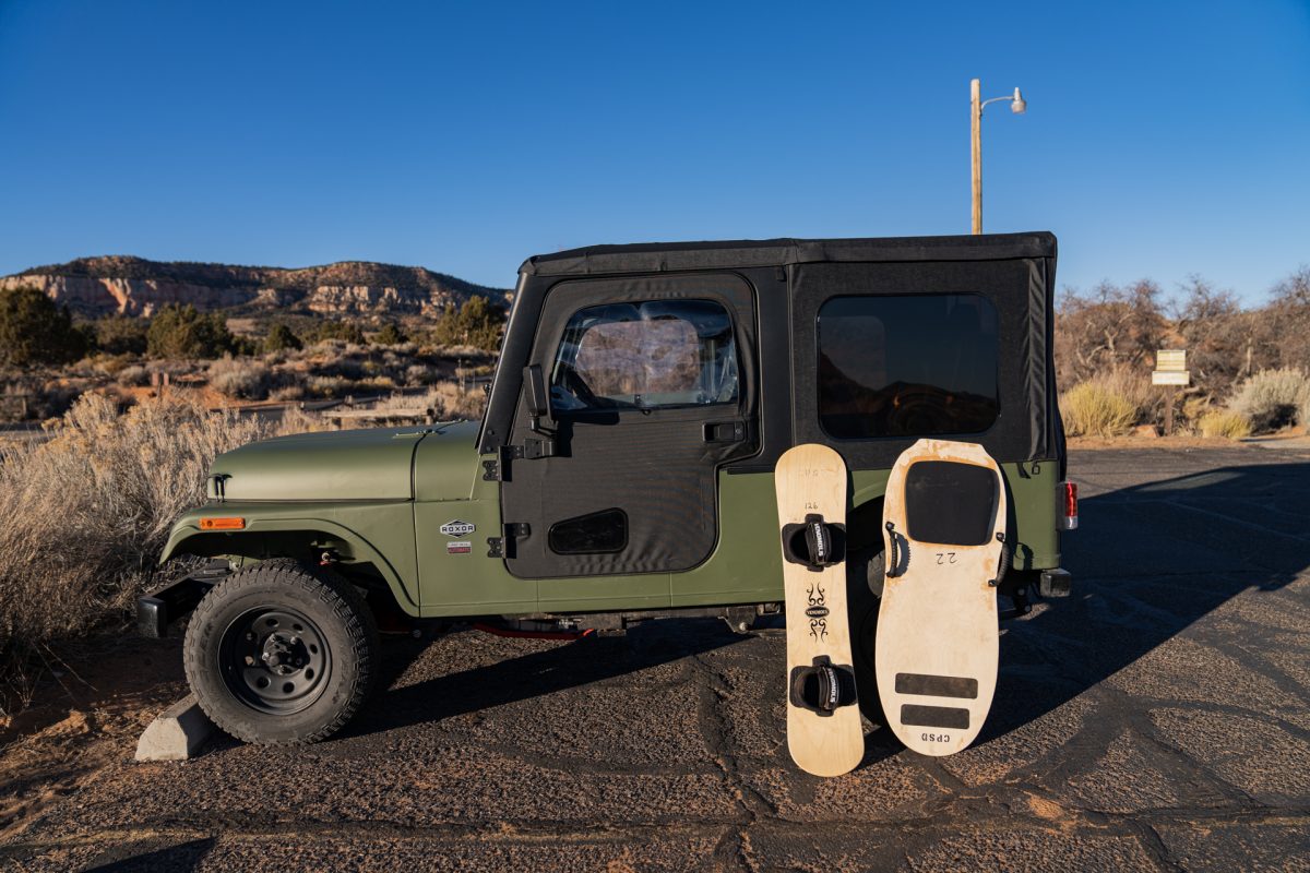 A ROXOR off-road vehicle with a sand sled and board leaning against it at Coral Pink Sand Dunes State Park located in Kanab, Utah.