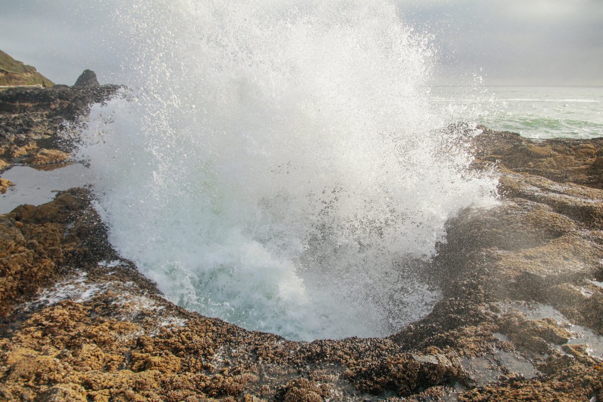 Waves coming through Thor's Well, a popular sightseeing activity for travelers visiting the Oregon Coast, a favored Oregon camping destination. 