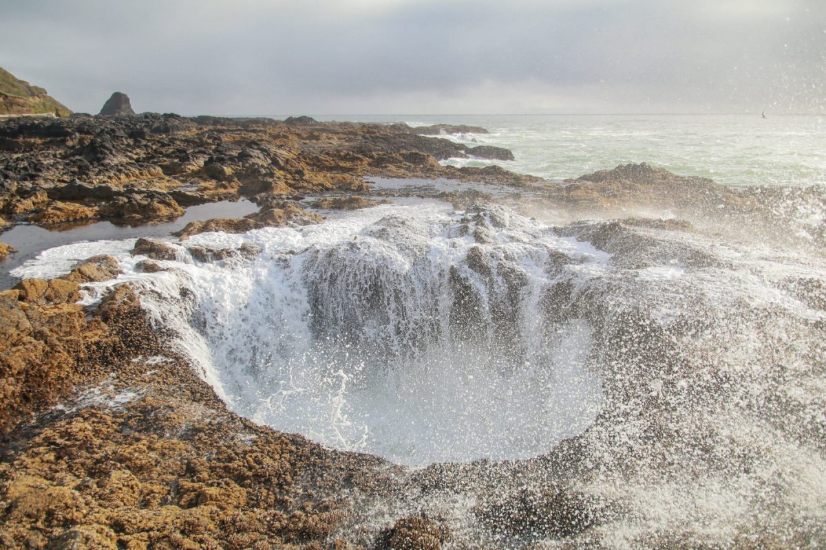 Waves coming through Thor's Well, a popular sightseeing activity for travelers visiting the Oregon Coast, a favored Oregon camping destination. 