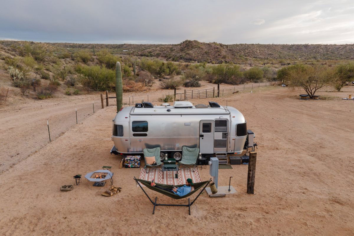 Man in hammock outside an airstream in the desert 