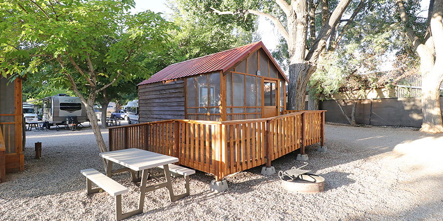 Cabin accommodation with tree in back at Canyonlands RV Resort & Campground