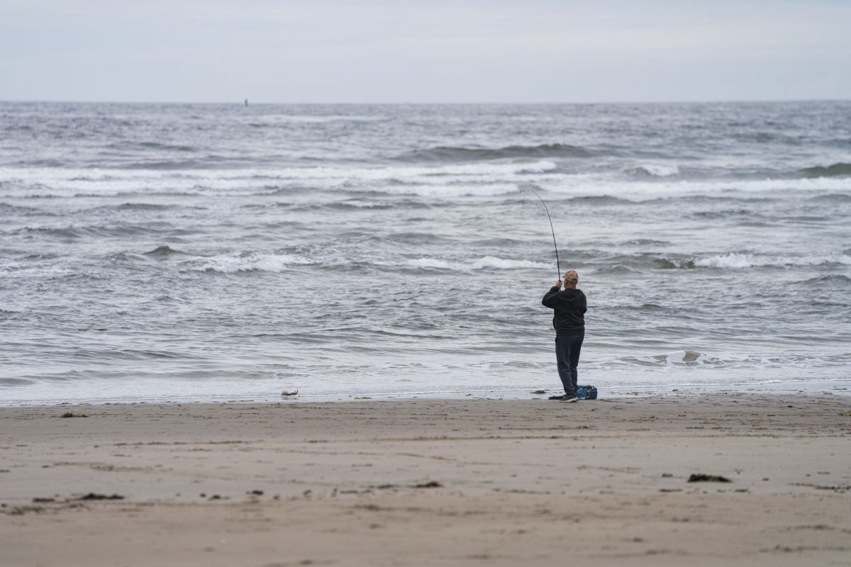 A fisherman fly fishing into the Pacific Ocean at Oceanside RV Resort and Campground in Coos Bay, Oregon.