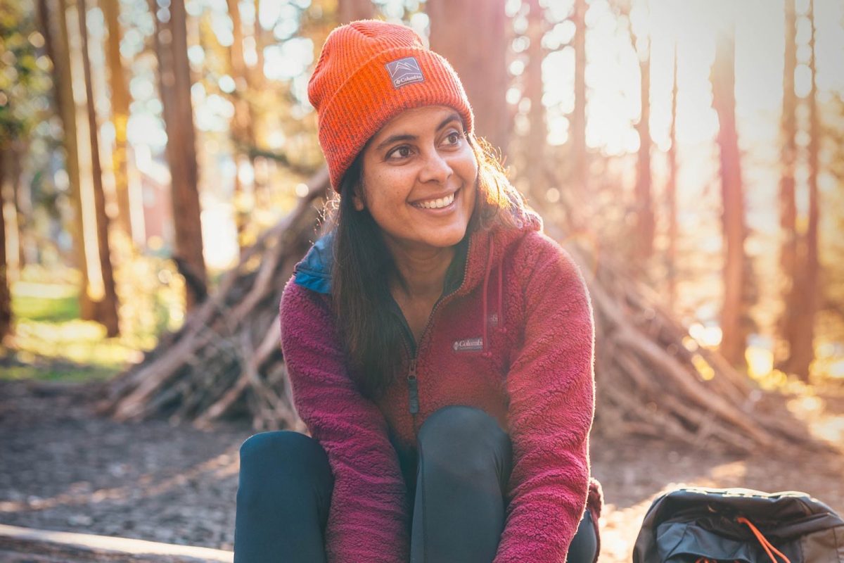 Outdoor enthusiast @eagertravele smiles as she adjusts her boots. 