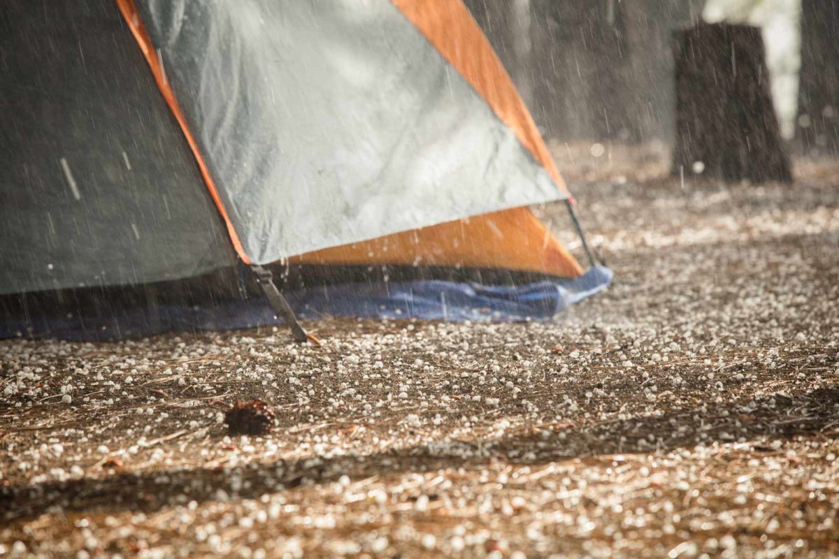 The base of a tent on the ground in the rain. 