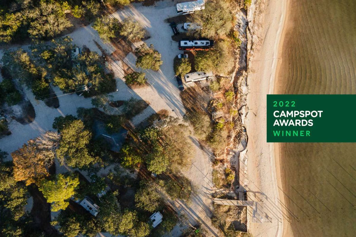 An aerial shot of campsites at a campground on the water. 