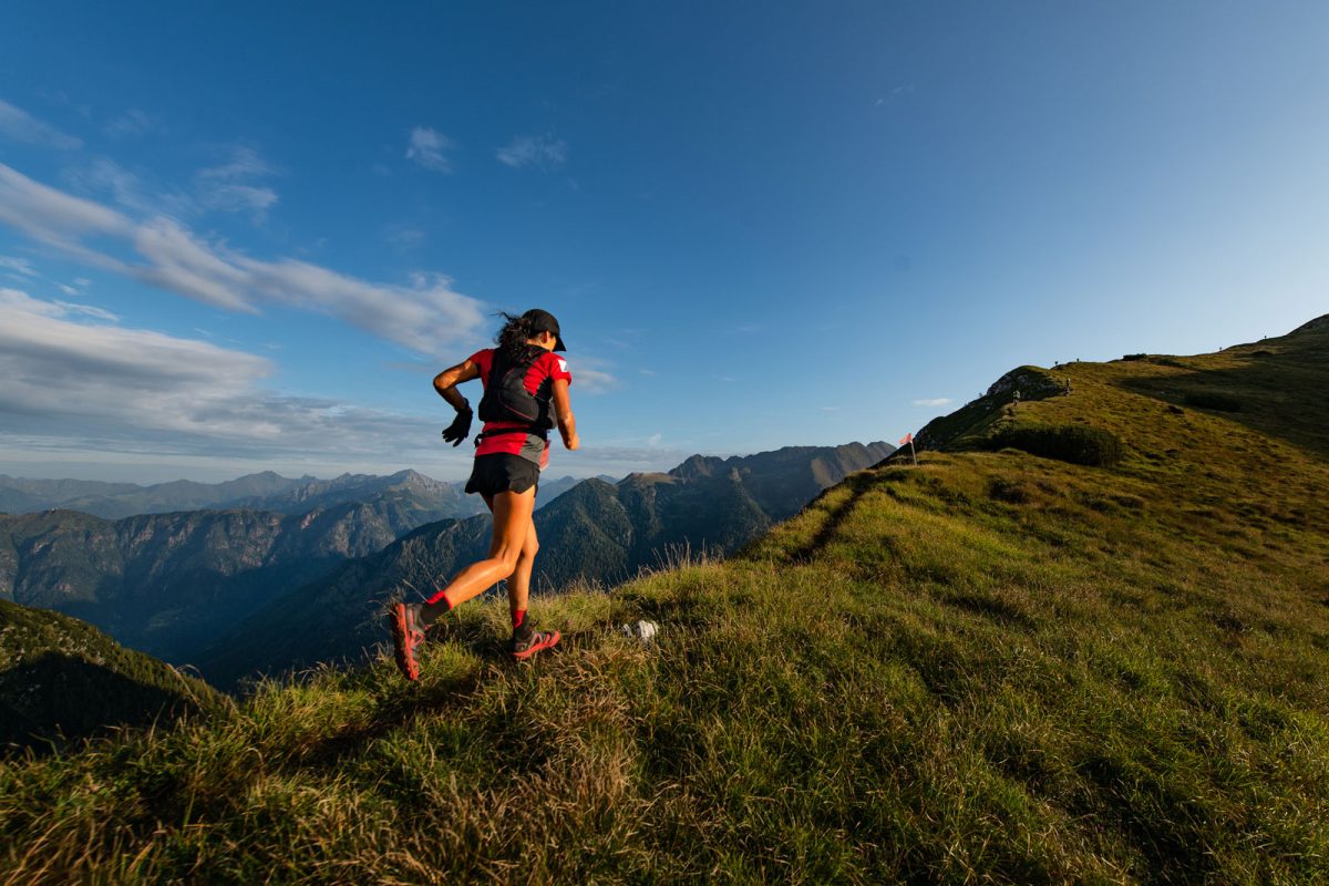 A runner follows a trail along a mountainside. 