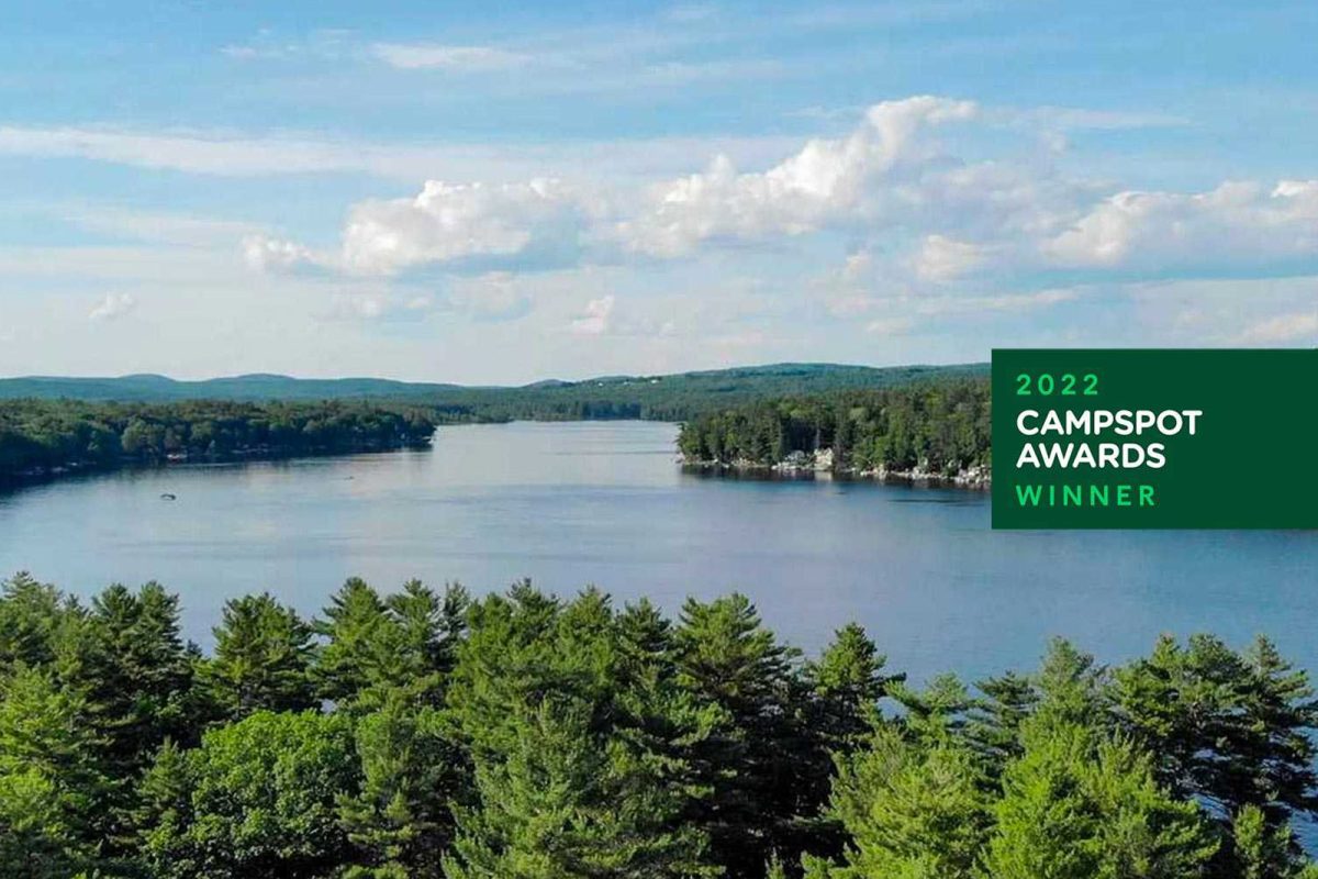 An aerial shot of a lake surrounded by trees at Yogi Bear's Jellystone Park™ Camp-Resort: Lakes Region. 