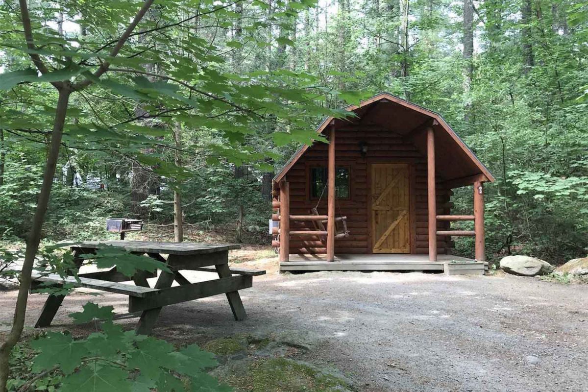 A cabin in the woods at Spacious Skies Minute Man Campground. 