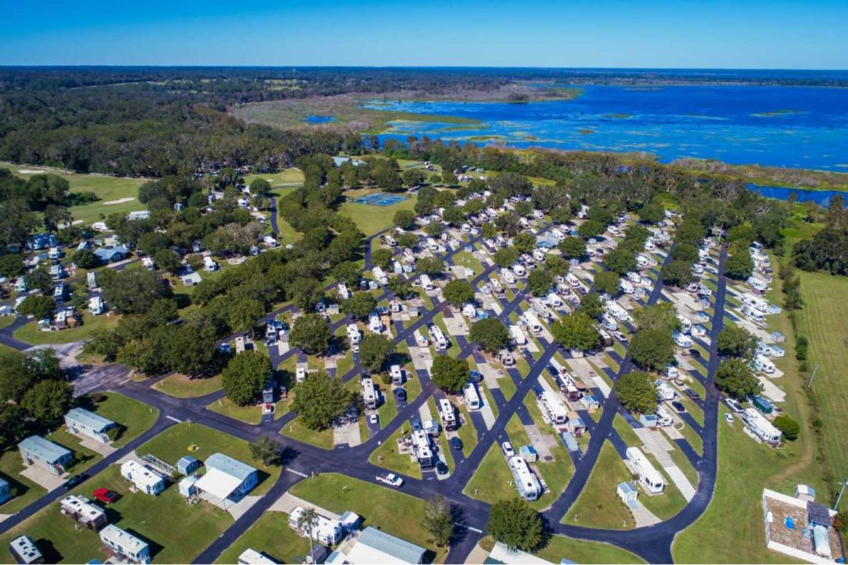 An aerial shot of the RV campsites Grand Lake RV & Golf Resort with a body of water in the distance. 