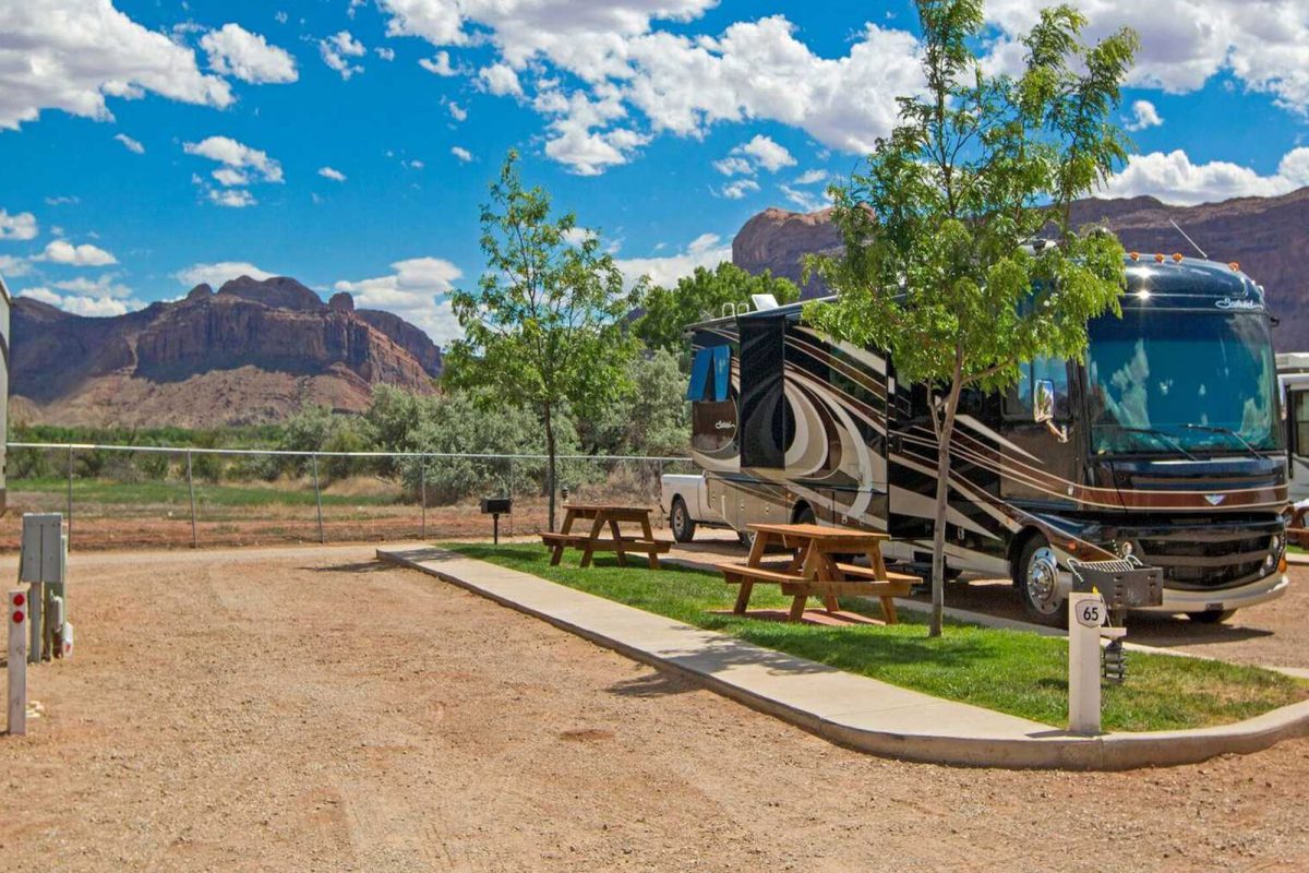 An RV parked at an RV site at Sun Outdoors Arches Getaway with mountain views in the distance. 