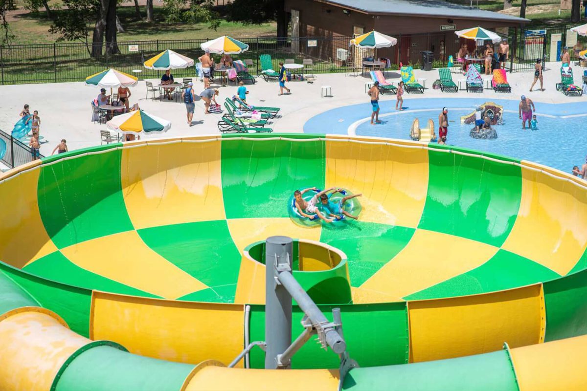 Two boys sit in an inner tub inside of a waterslide at Camp Fimfo Texas Hill Country. 