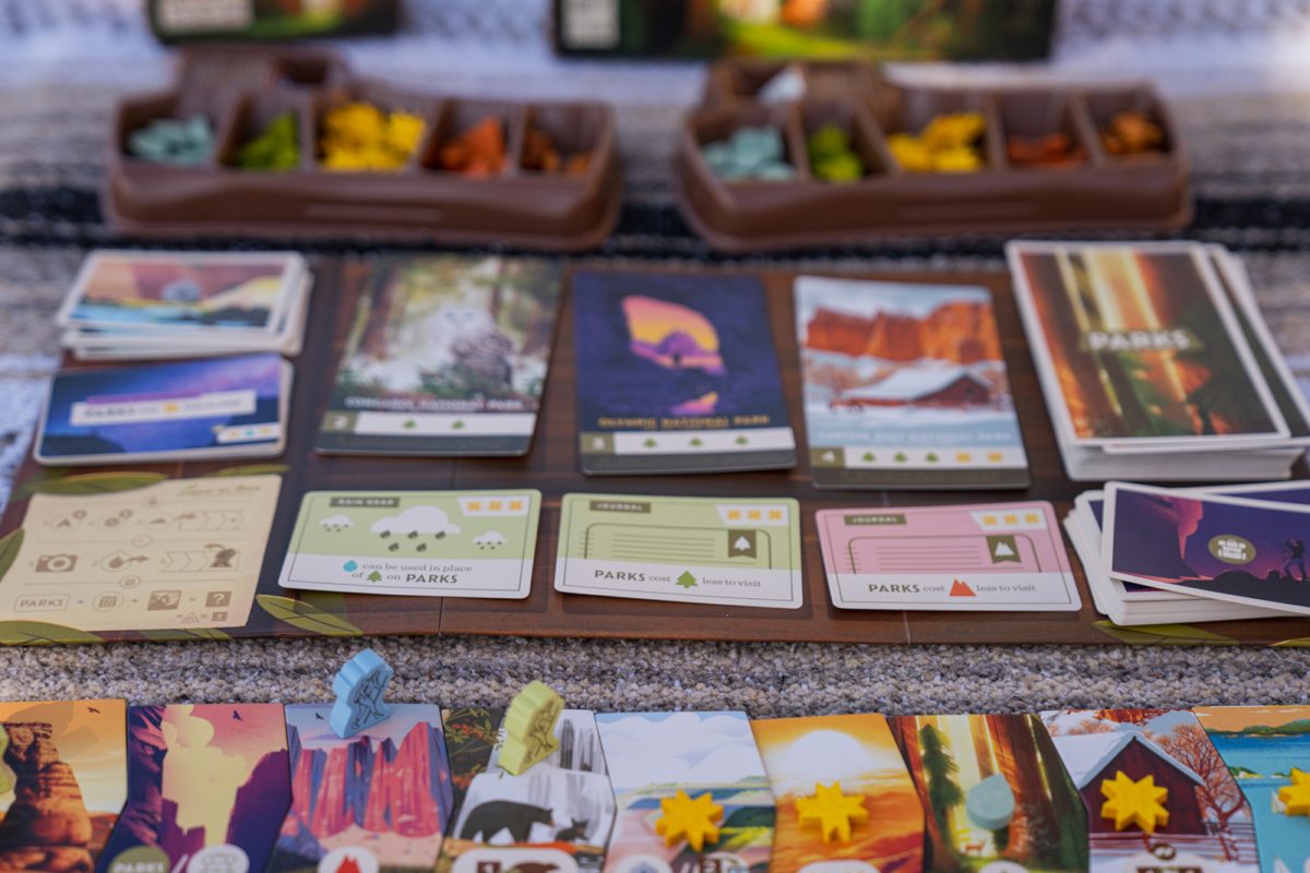 A card game and game pieces are placed on top of a blanket. 