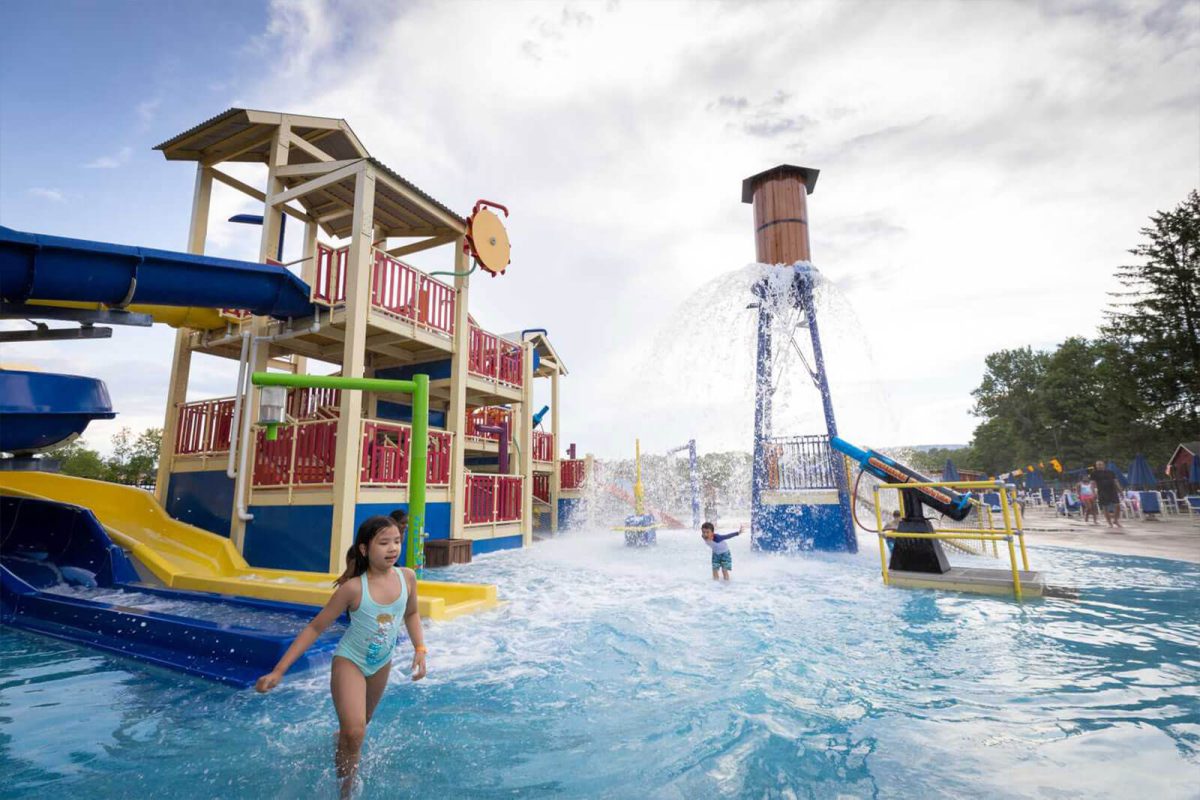 Water dumps on a child from above at the water park at Yogi Bear's Jellystone Park™ Camp-Resort: Gardiner. 