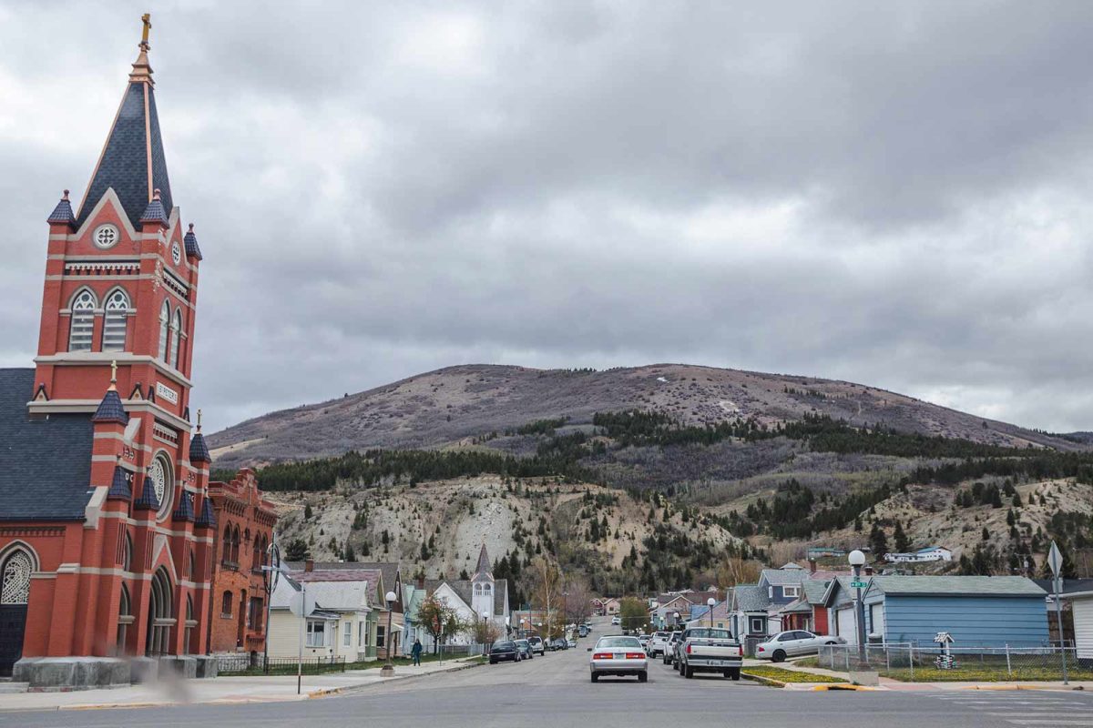 An image of a church and street in Anaconda, Montana with a mountain view in the background. 