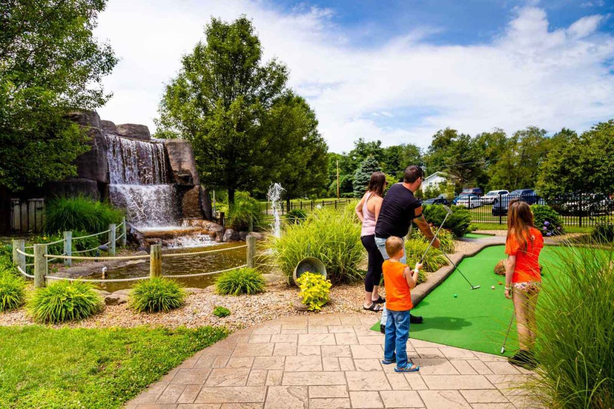 family playing mini golf on campsite