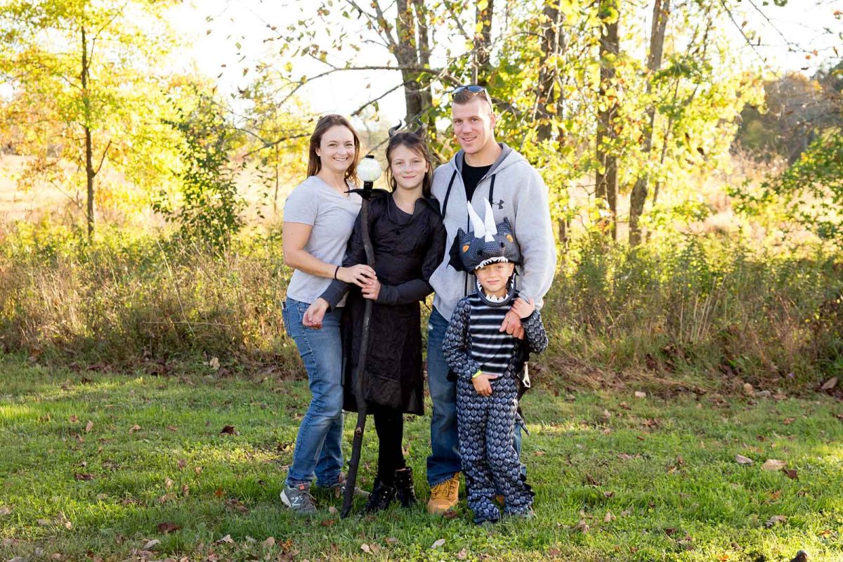 family posing for photo, children dressed in Halloween costumes