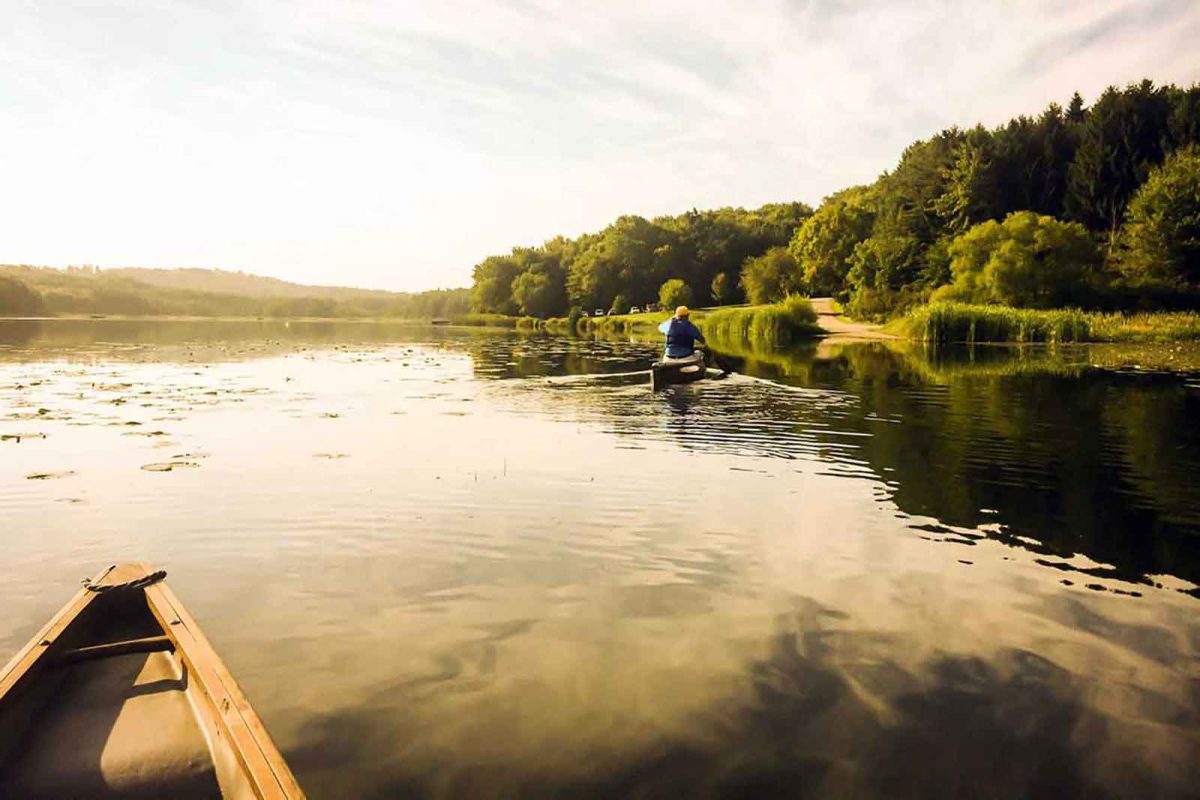 person canoeing on lake