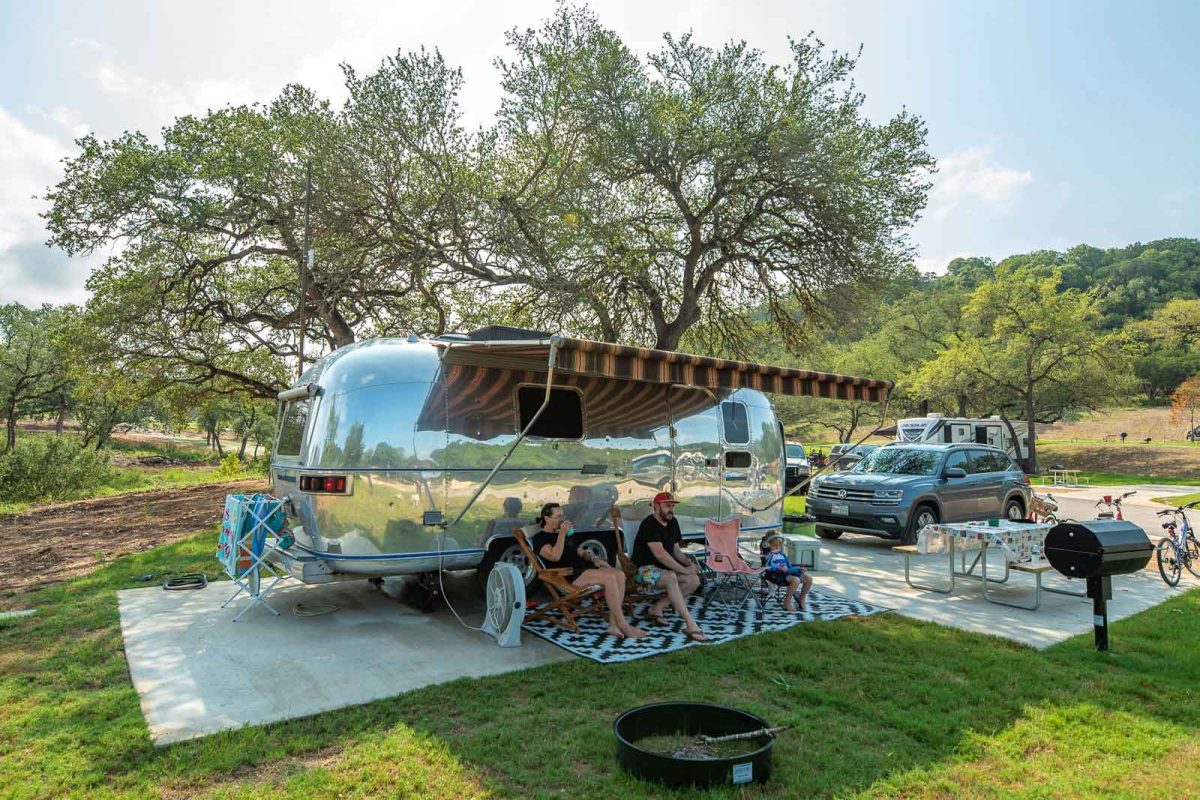 family enjoying weather next to airstream