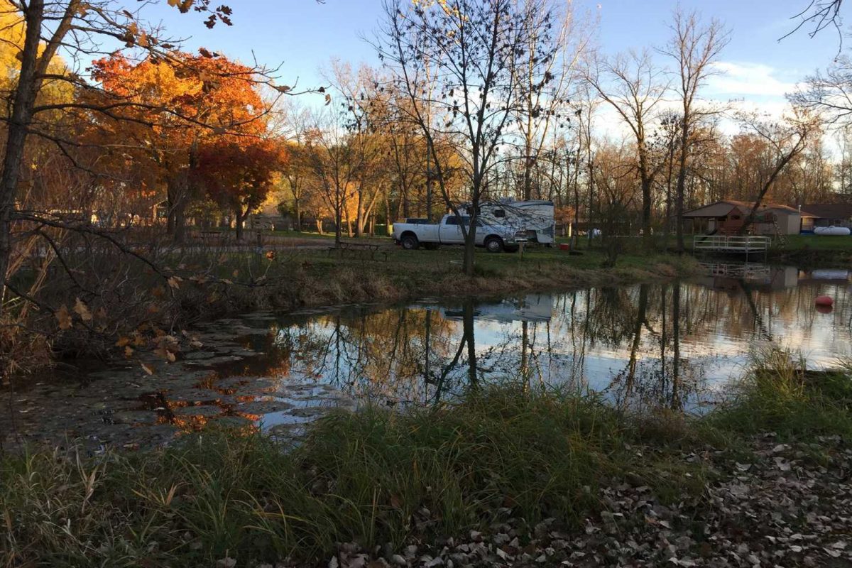 truck and RV parked on campground near NFL stadium during fall