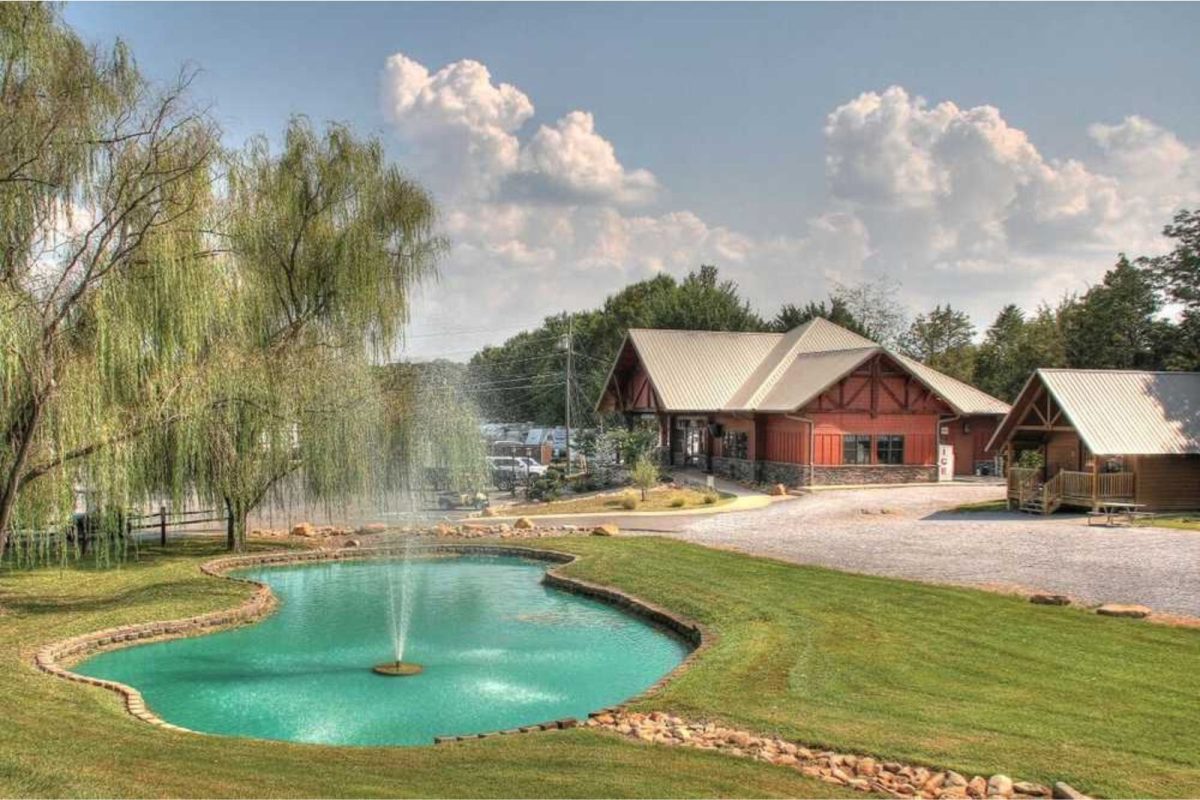 Gatlinburg campground with fountain and pool in front of red lodge and willow tree