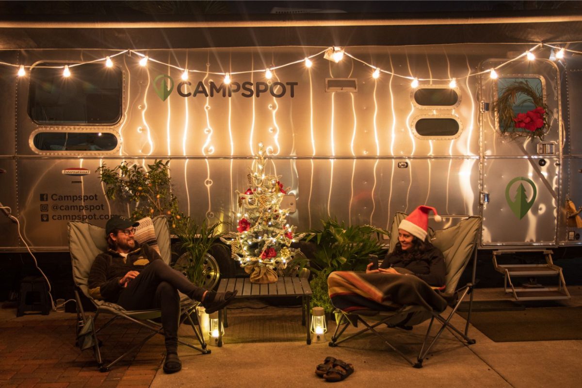 couple sitting outside their RV after decorating a campsite