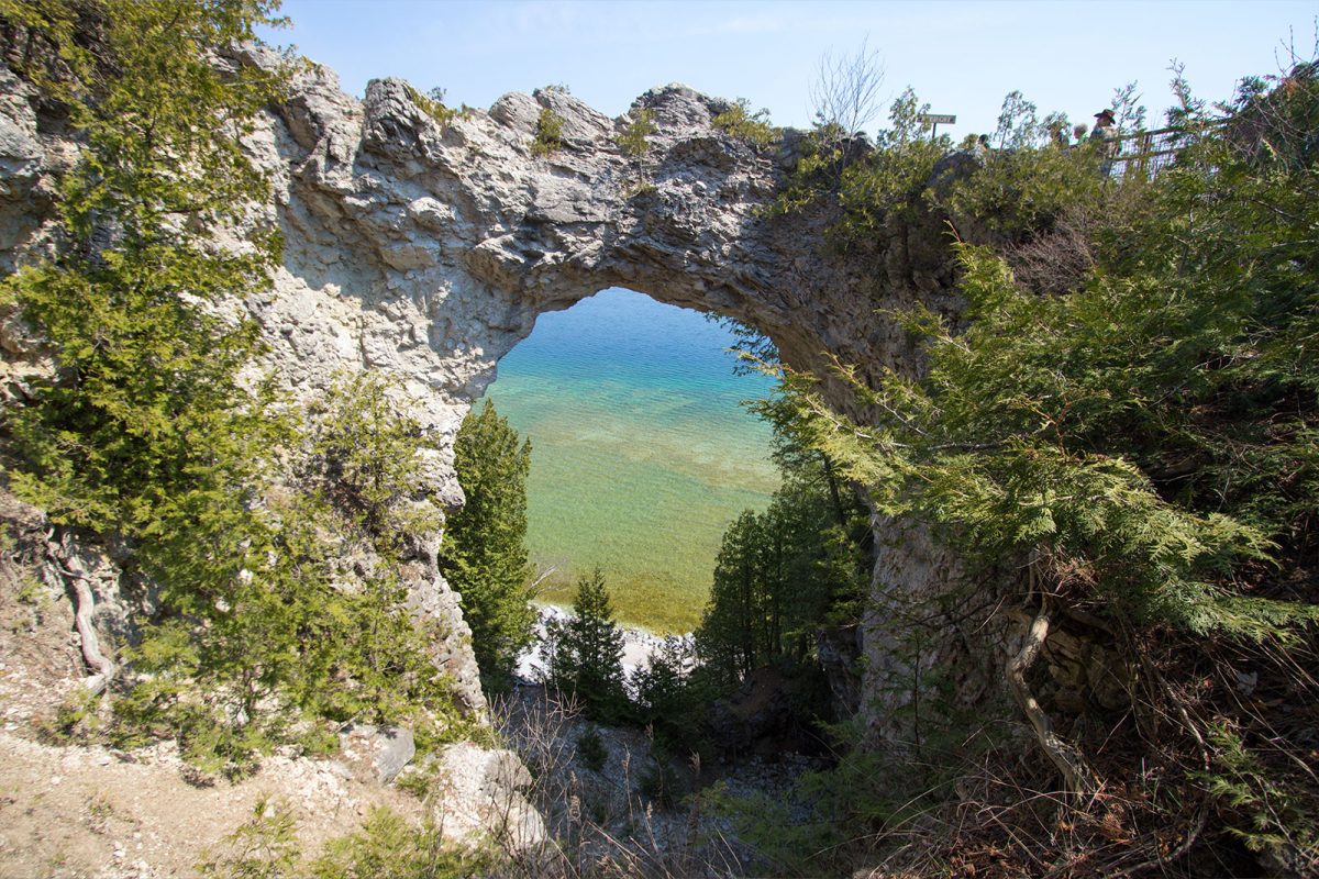 arch inside canyon looking out onto the water