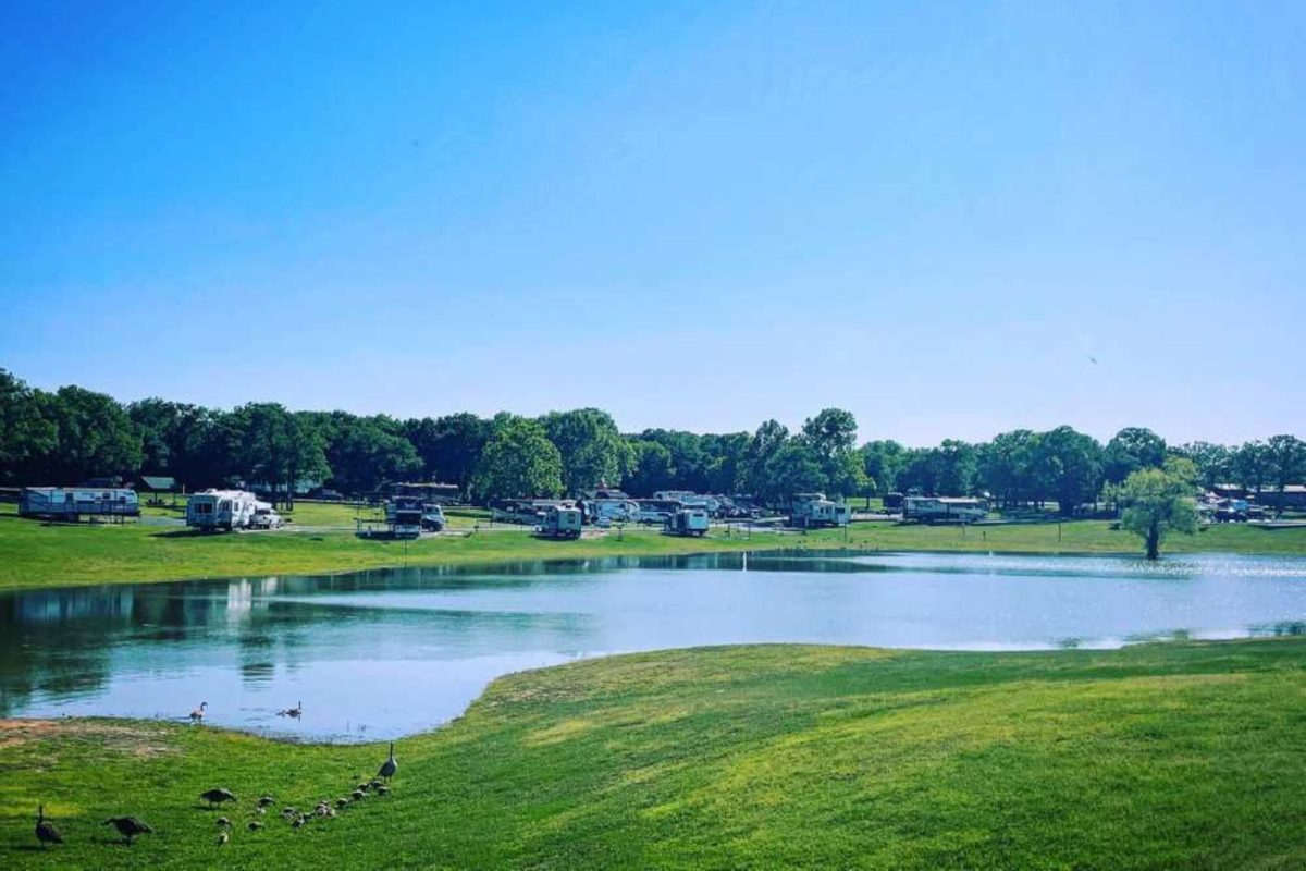 RVs parked at campground near Fort Worth, TX with a lake and ducks nearby