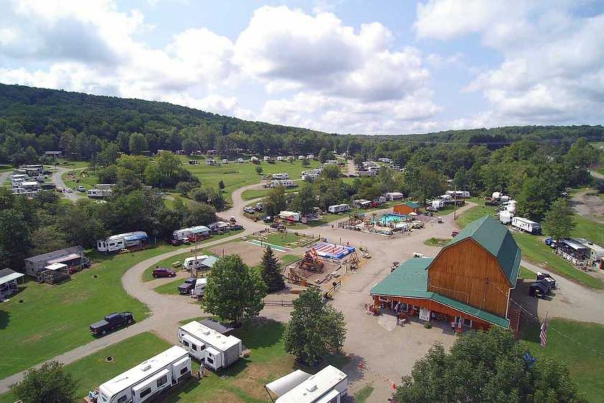 campground near Buffalo, NY with green cabin lodge, pool, and RVs