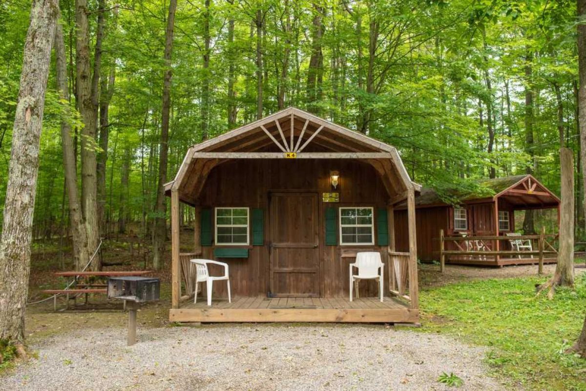 wood cabin with green shuttered windows at campground in the forest