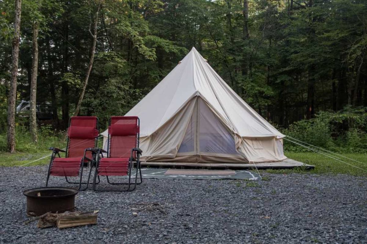 yurt with two red chairs with backdrop of trees at campground for weekend getaway from NYC