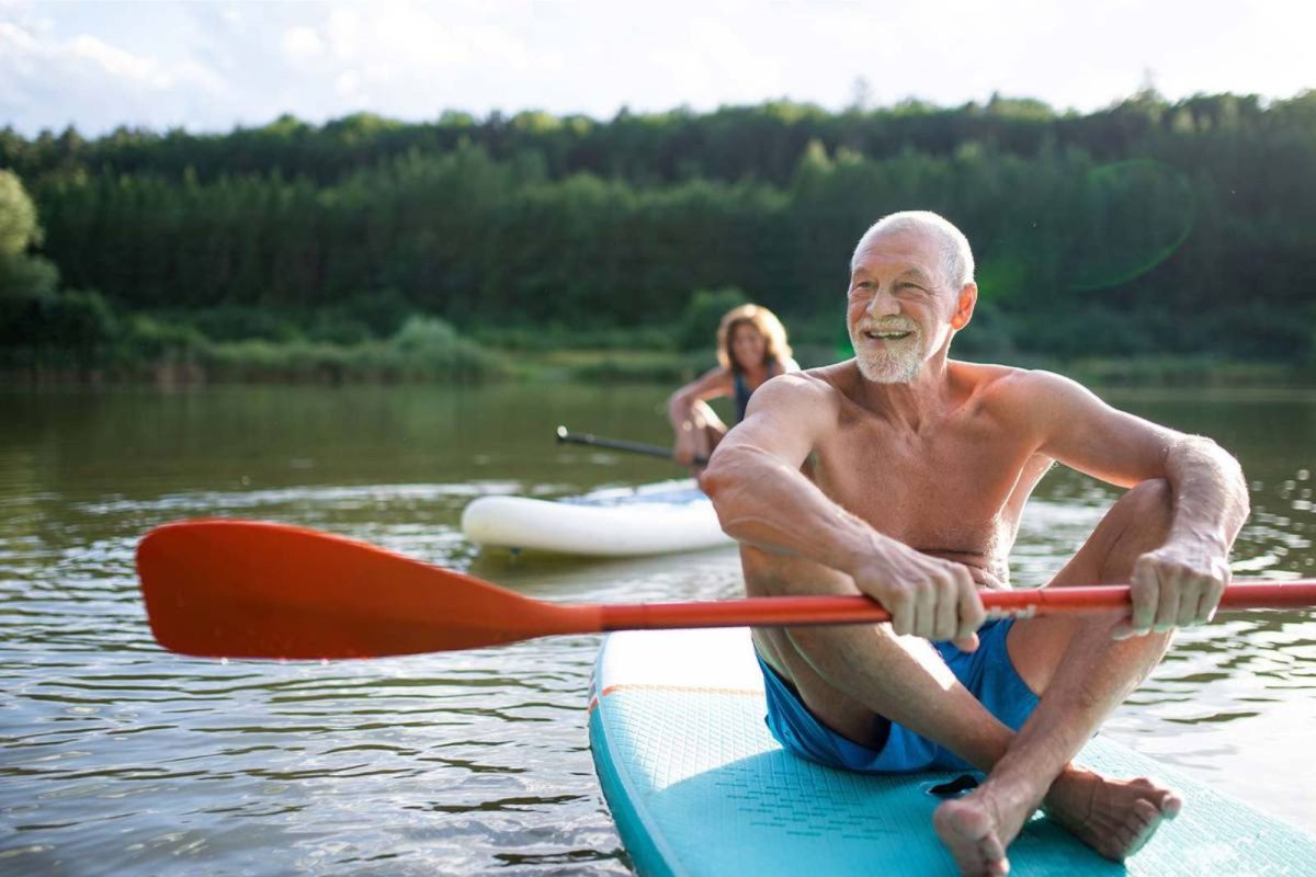 man sitting on paddleboard with oar