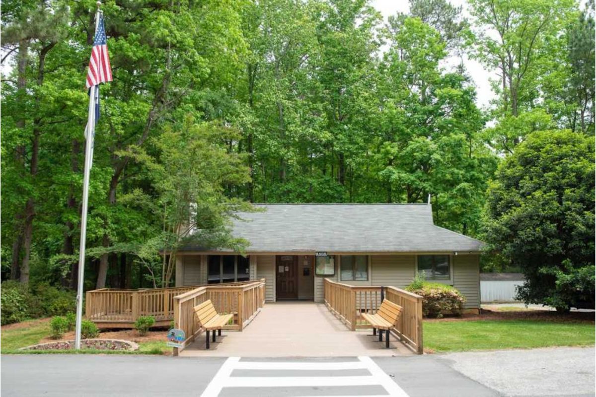 view of visitor center with flag among tall trees at this winter camping destination