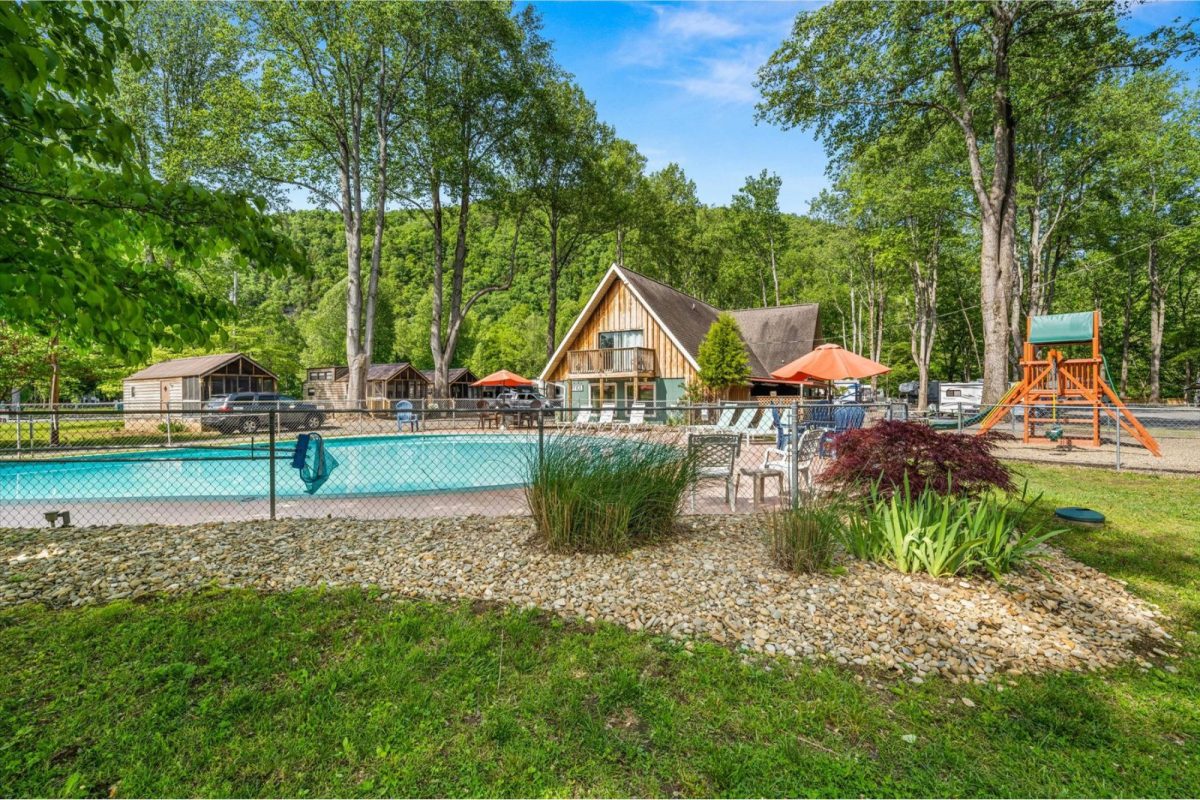 cabin and lodge next to pool and playground at Mountaineer Campground