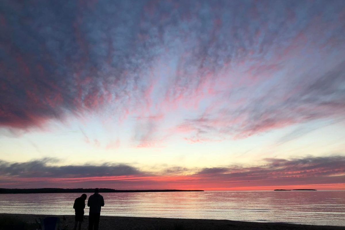 two people on beach at sunset at Munising Tourist Park Campground