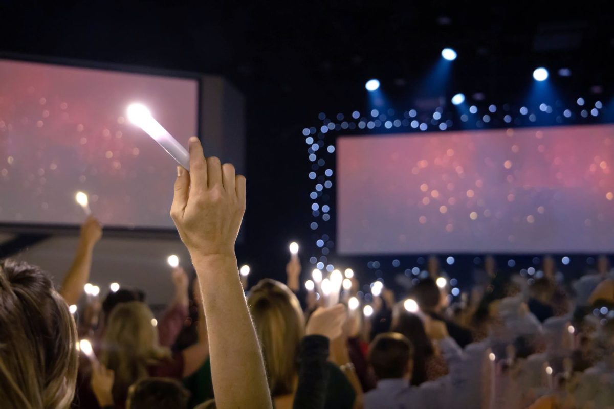 crowd holding LED candles at vigil service concert