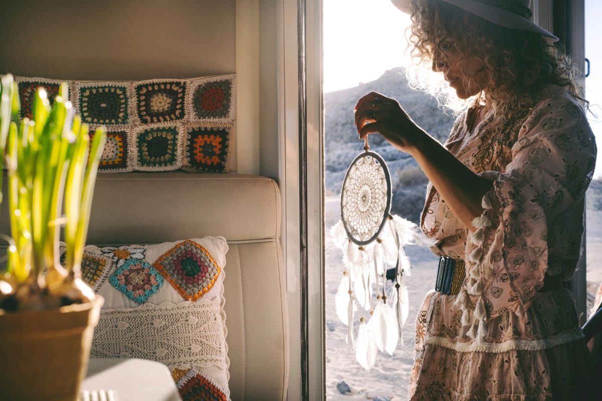 woman decorating her RV with dreamcatcher and pillows