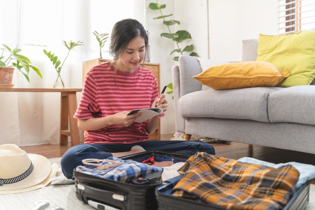 Asian woman using camping checklist to pack for last-minute camping getaway under $300