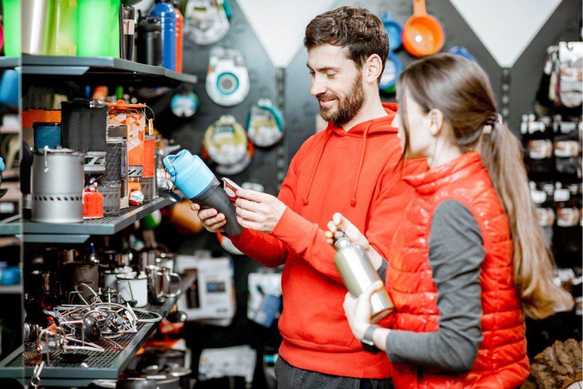 young couple browsing camping gear for camping trip under $300