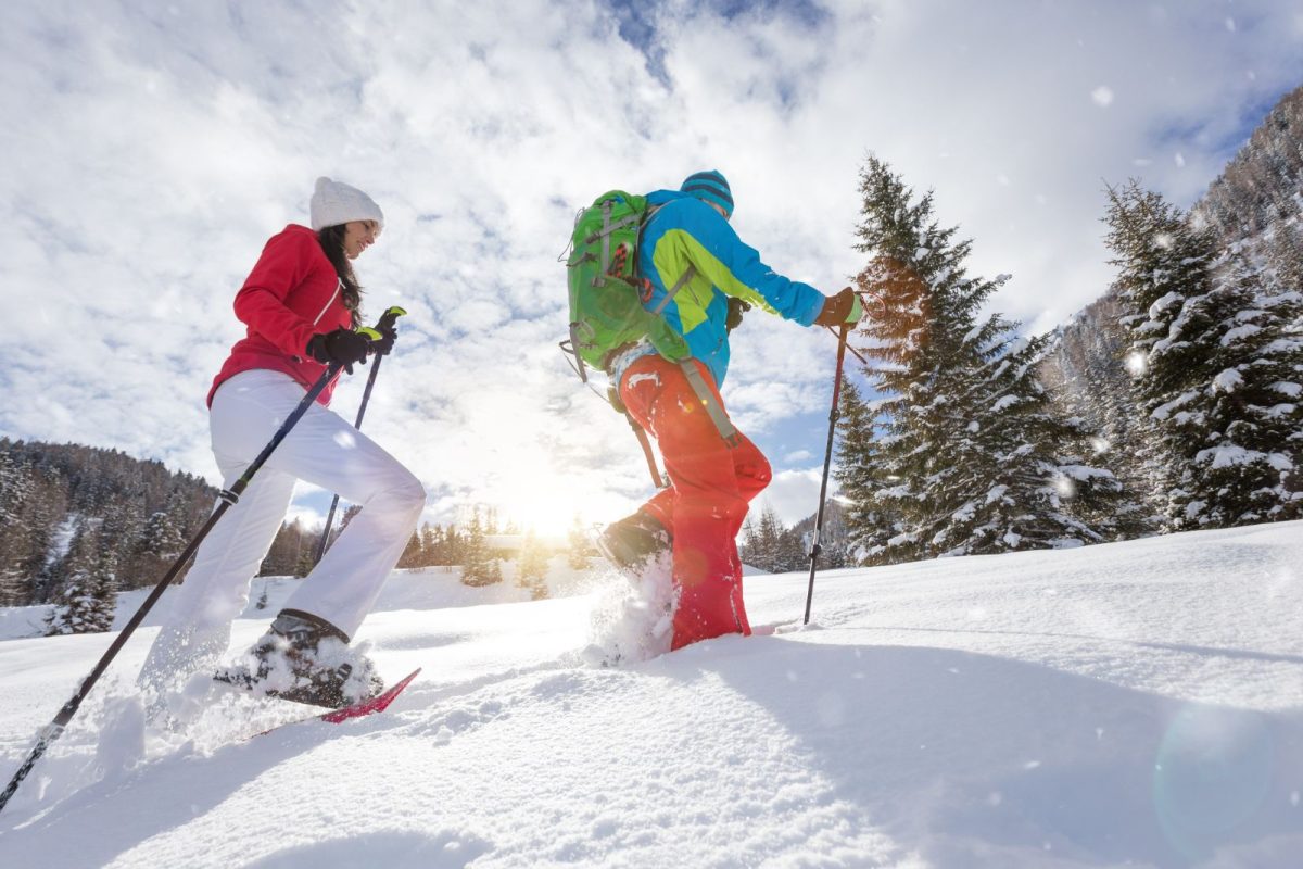 two campers snowshoeing in snow while winter camping