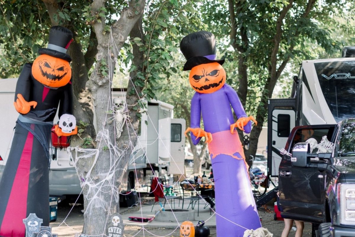 Halloween pumpkin inflated decorations and RVs parked campground for fall camping festivities