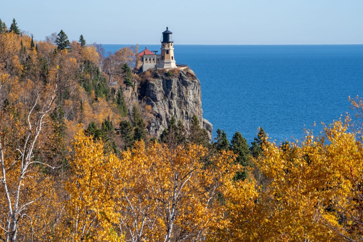 view of lighthouse and Split Rock of Lake Superior over fall trees at one of top camping destinations Duluth