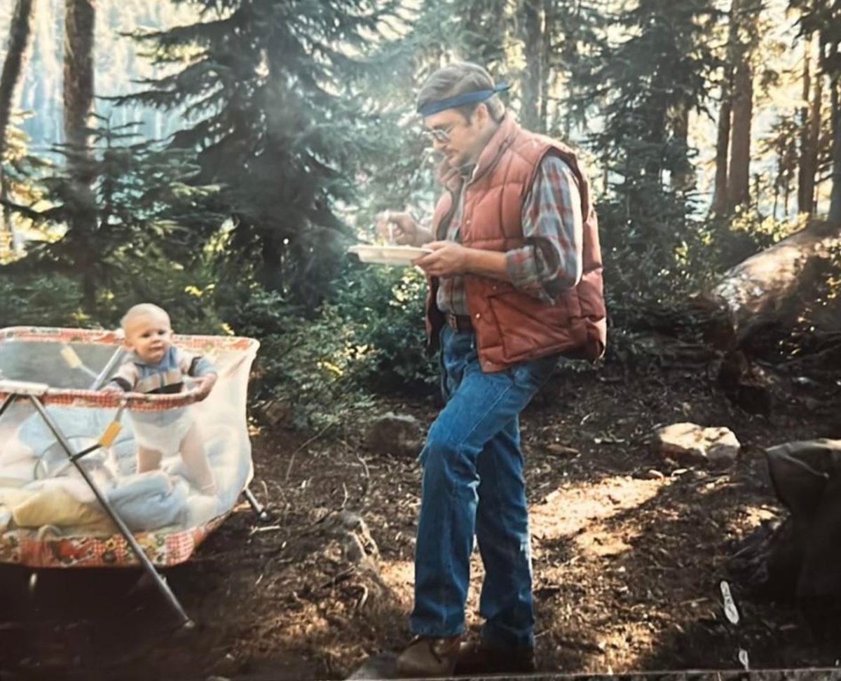 1980s photo of camping dad with baby in bassinet