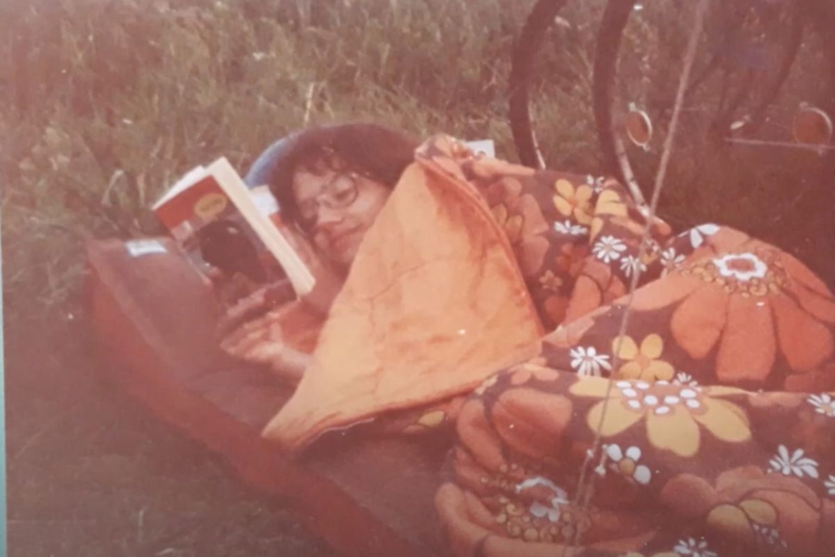 1980s photo of camper in orange sleeping bag