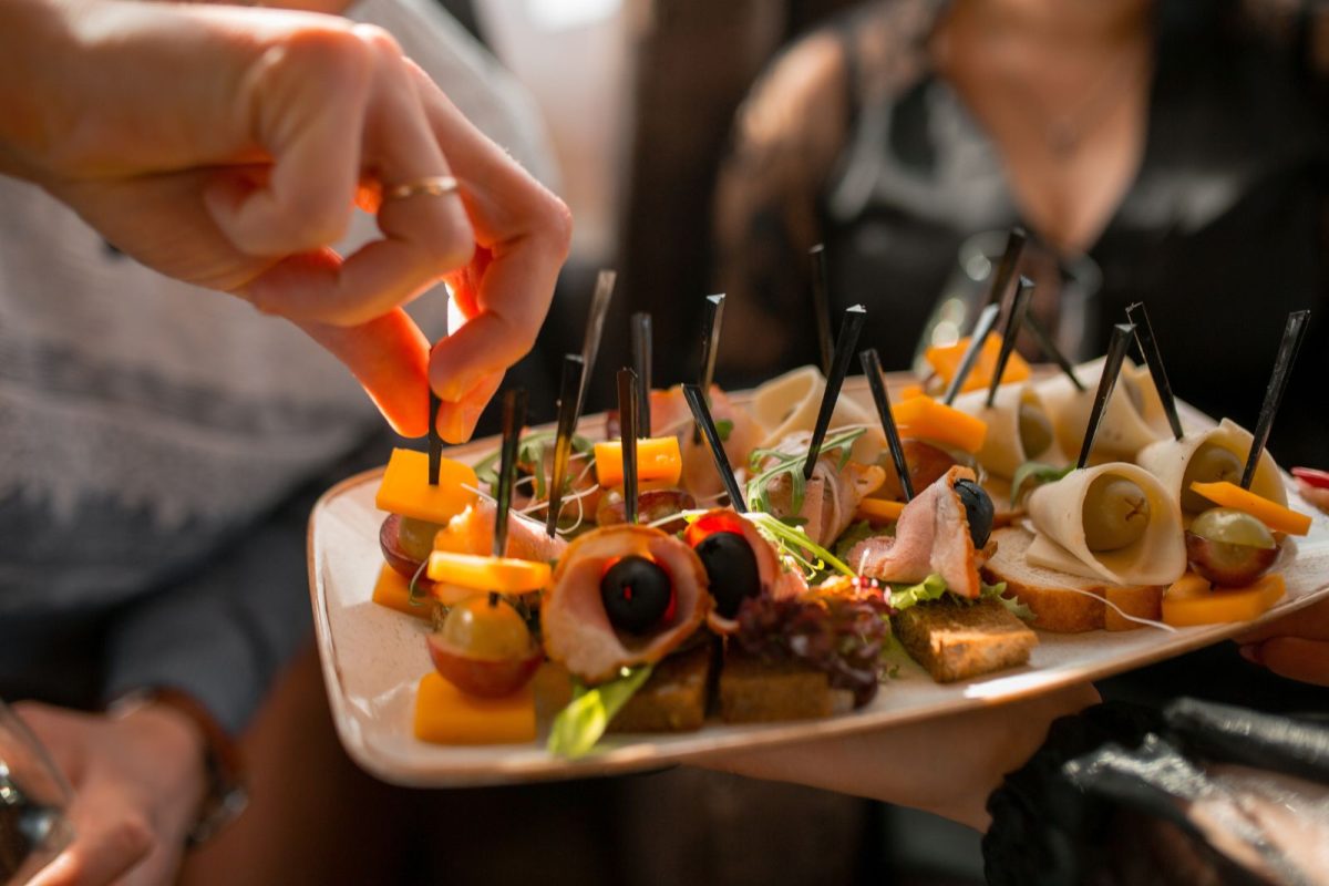 person picking up skewered appetizer off plate for RV gathering