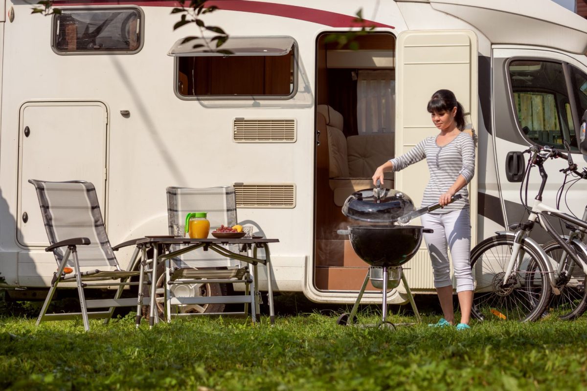 woman grilling outside to host gathering at her RV