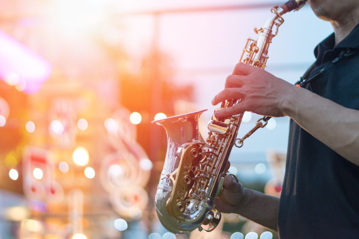 man playing saxophone at concert for a camping event