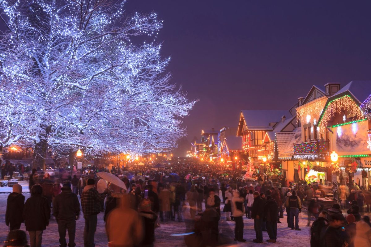 people walking around lit-up tree and buildings at Leavenworth Village of Lights, top choice among Christmas camping events